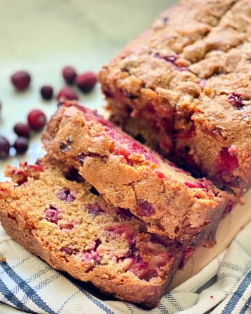 square photo of Cranberry Bread sliced on a cloth.