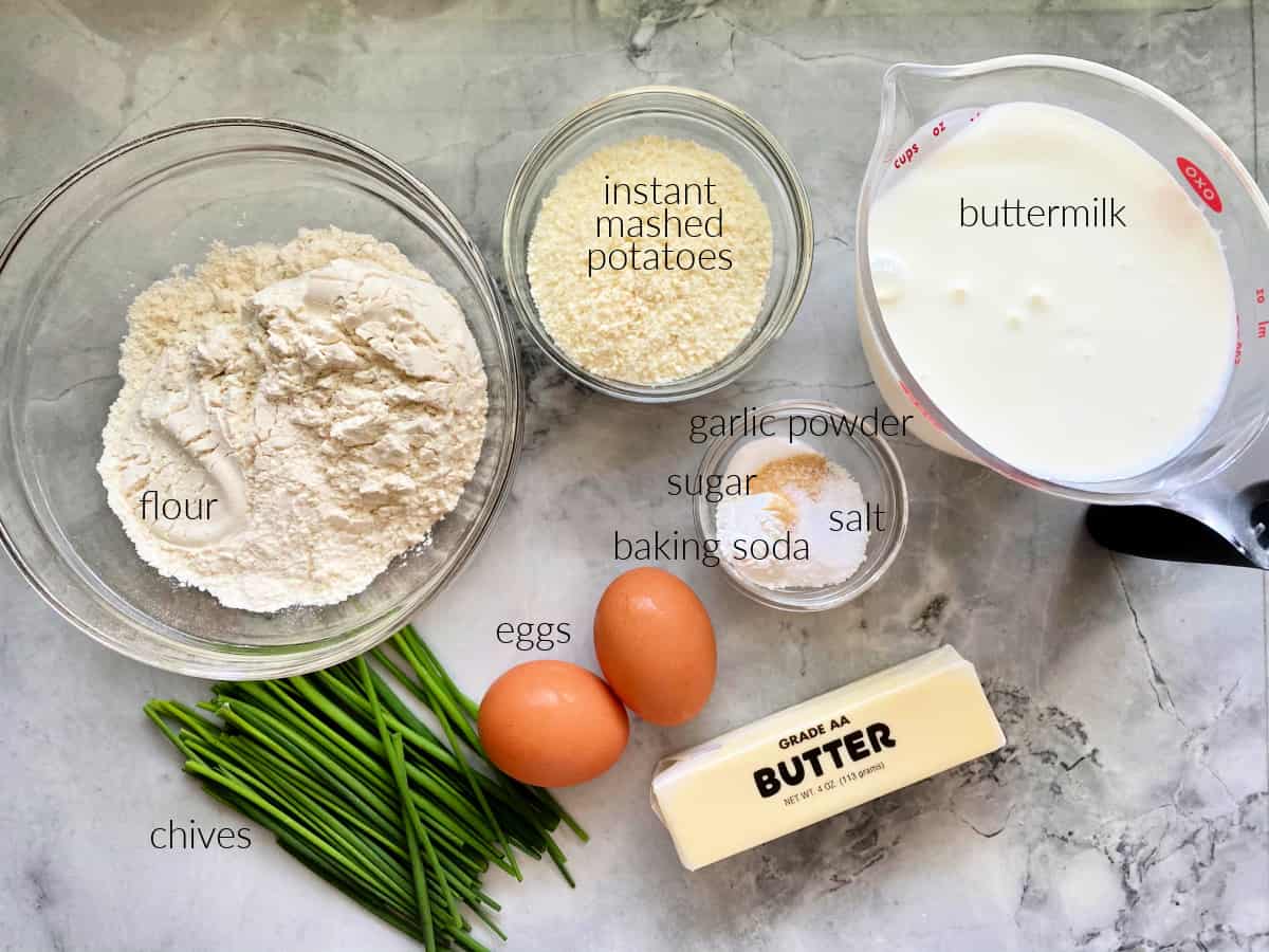 Ingredients on counter: flour, instant mashed potatoes, egg, seasonings, butter, chives, and buttermilk.