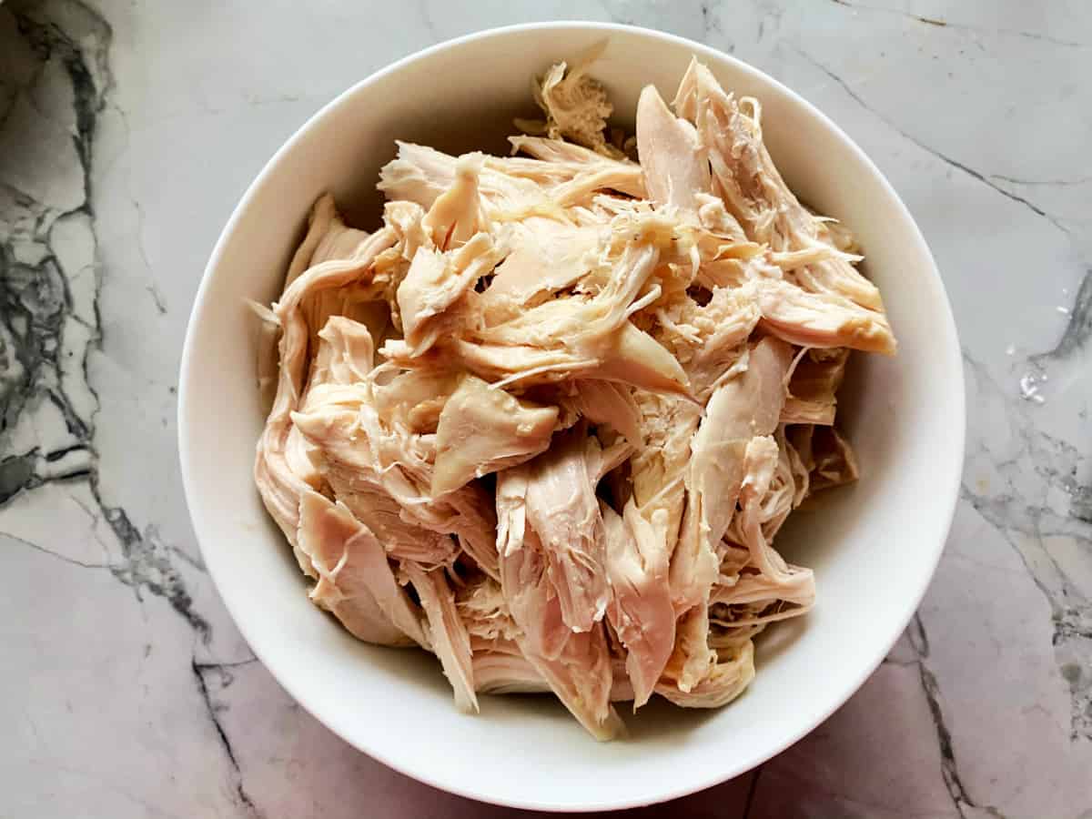 Shredded rotisserie chicken in white bowl