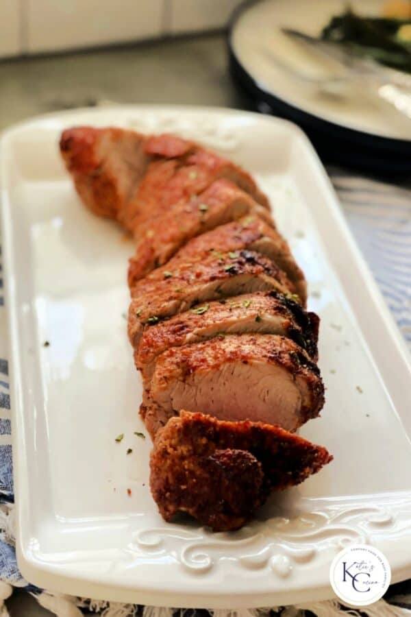 Sliced pork tenderloin on white serving dish