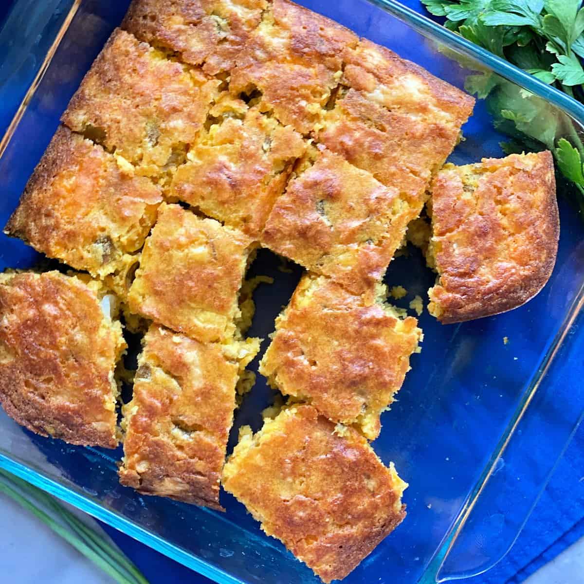 top view shot of thirteen slices of cornbread in square glass baking dish