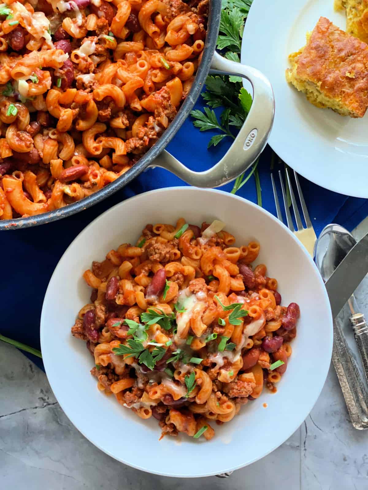 Chili pasta in white bowl with skillet in background