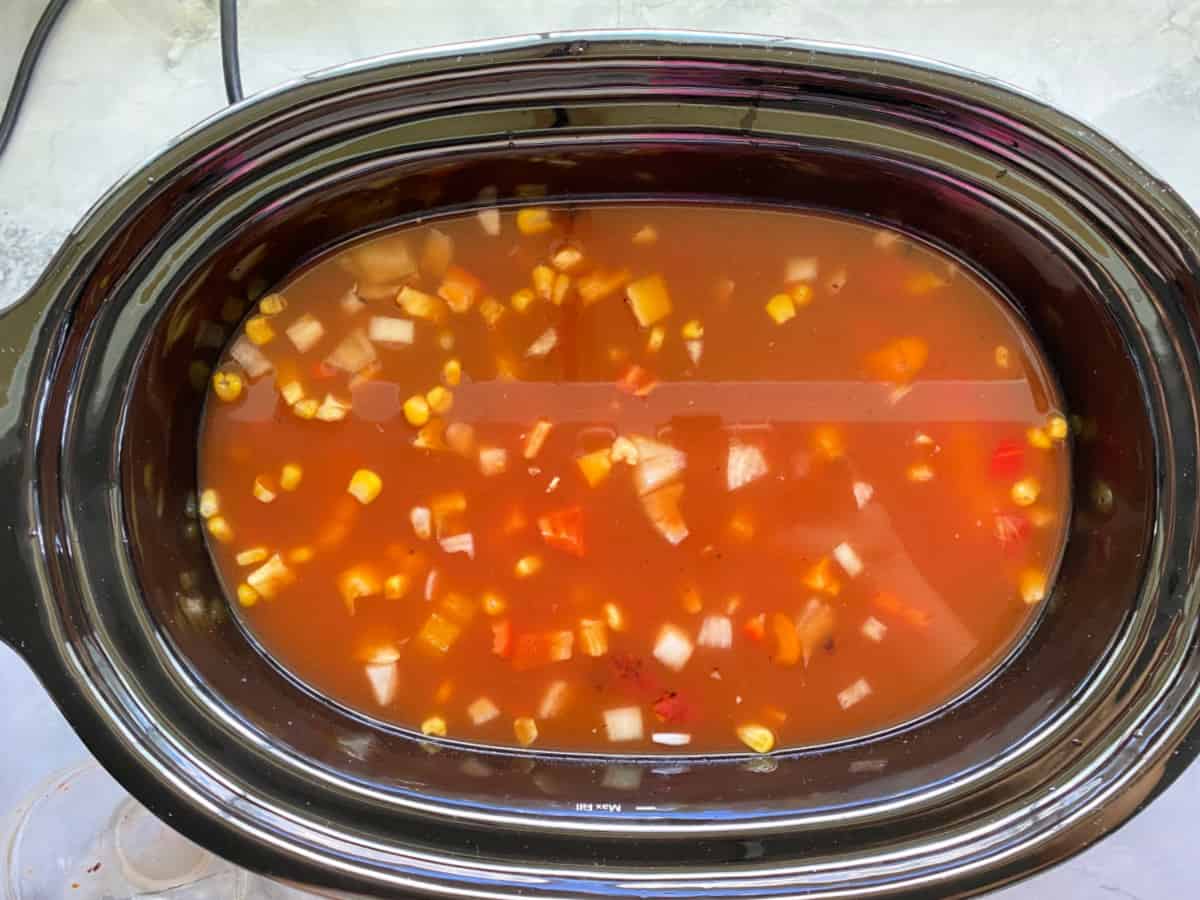 Water added to chicken enchilada soup ingredients inside crock pot