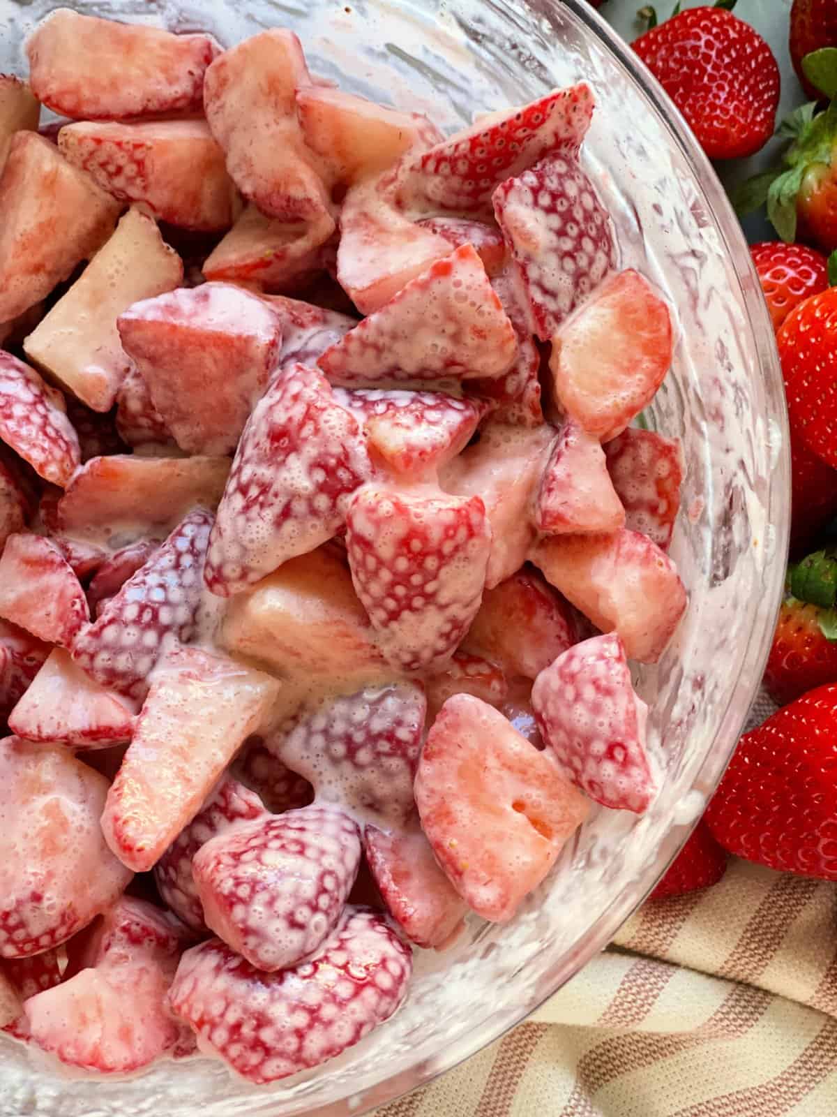 Strawberries and cream ingredients combined together in glass bowl