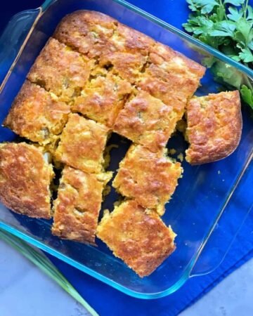 square glass pan with cornbread cut into squares.