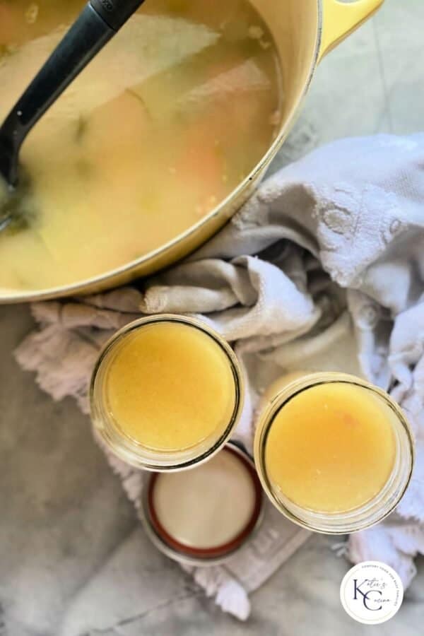 top view shot of two jars of stock next to dutch oven filled with stock