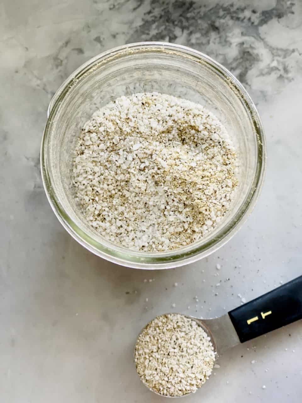 Top view shot of house seasoning in glass jar and in 1 tablespoon