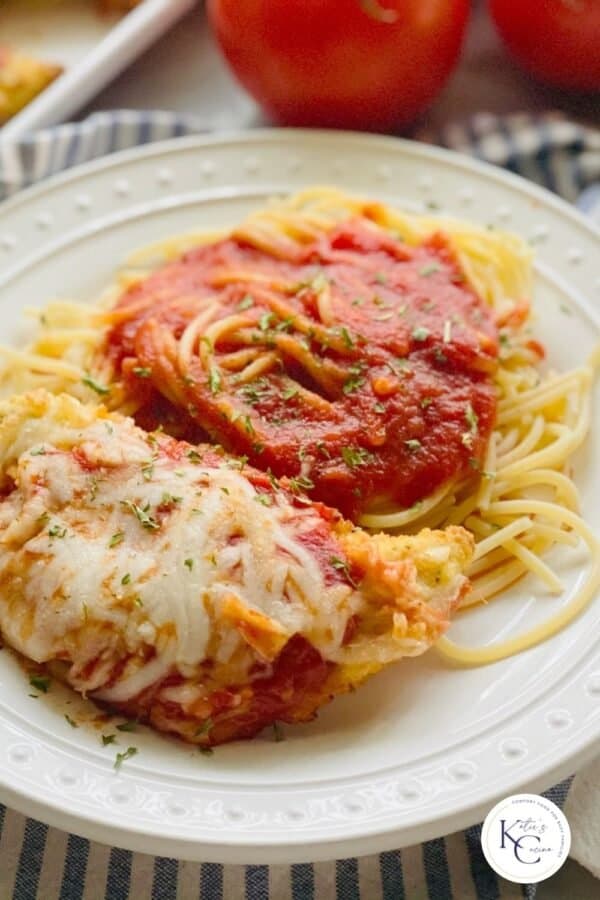 Chicken parmesan and pasta on a white plate