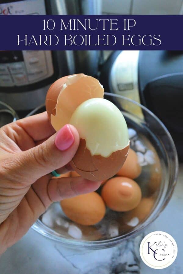 Hand with pink nails holding a perfectly shelled hard boiled egg with recipe title text on image for Pinterest.