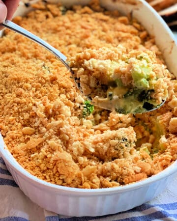 Broccoli Cheese Casserole spooned out of white baking dish