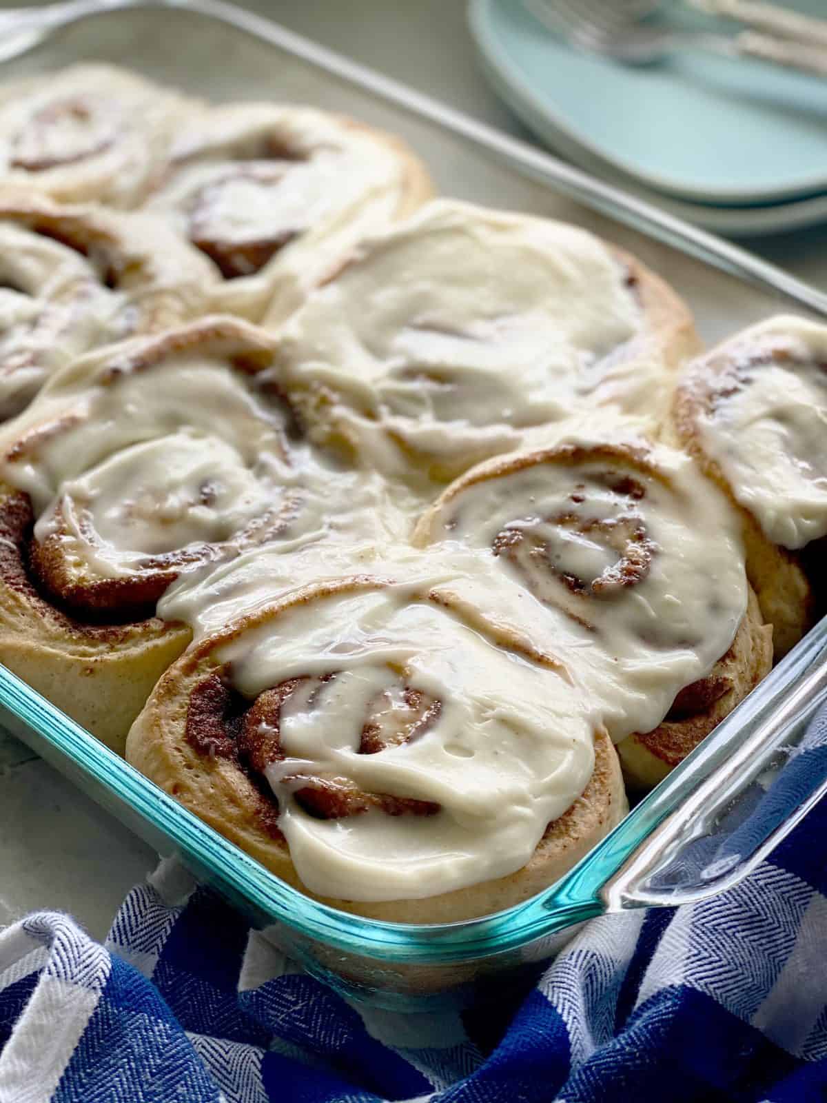 Glass baking dish with frosted cinnamon rolls.
