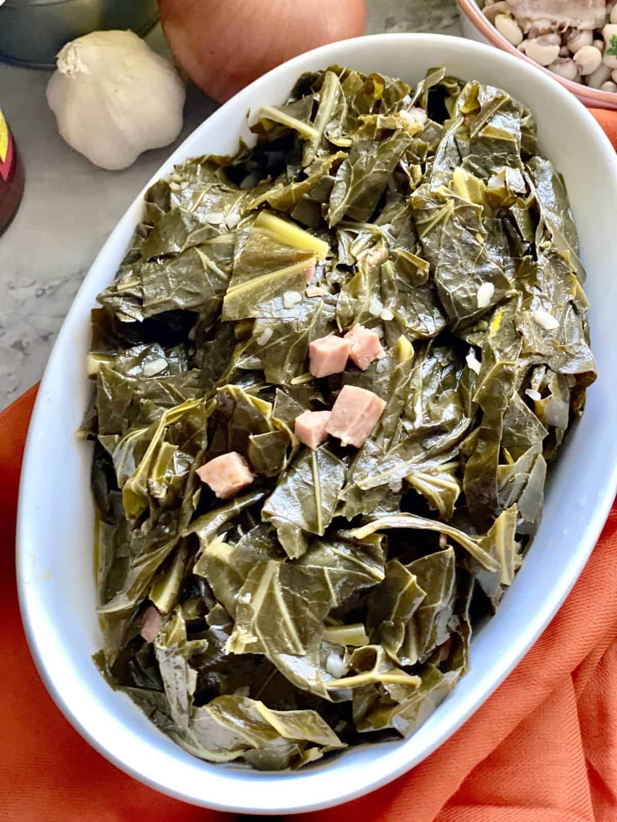 Top view of cooked collard greens in white serving dish