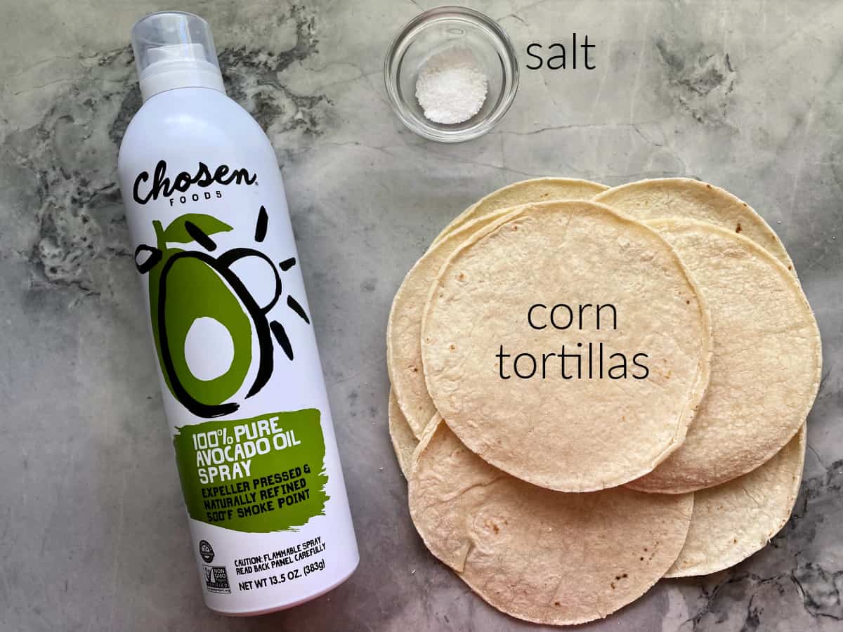 Ingredients on counter; corn tortillas, salt, and avocado oil.