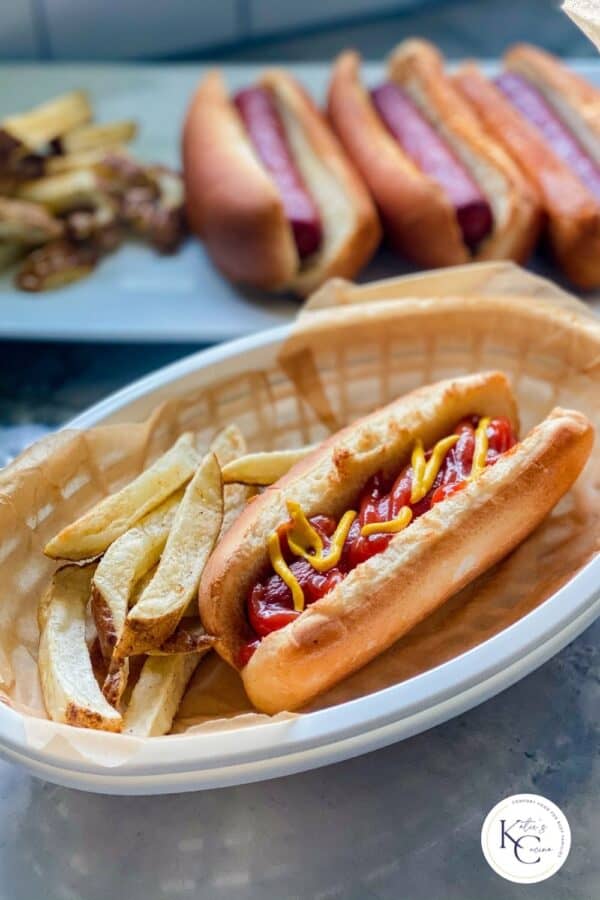 A hot dog in a basket lined with paper and a side of fries