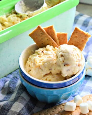 Two bowls stacked with ice cream and graham crackers sticking out of bowl.