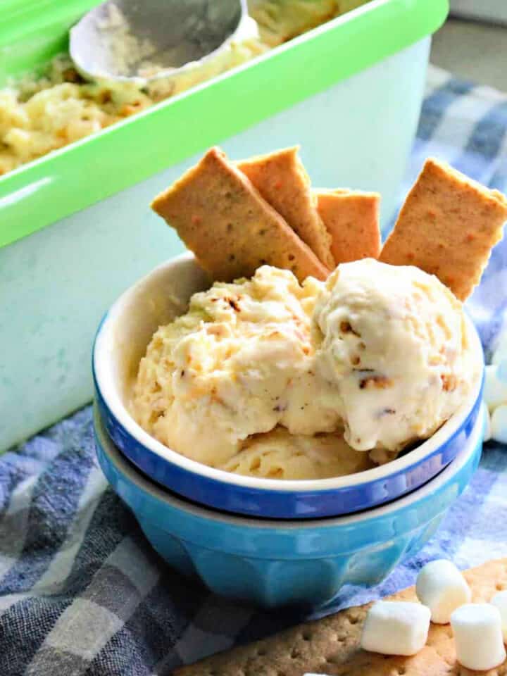 Two bowls stacked with ice cream and graham crackers sticking out of bowl.