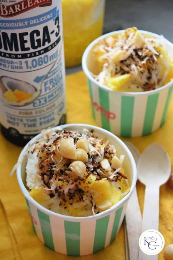 two paper cups with ice cream sundaes and wooden spoons next to it with recipe title text on image for Pinterest.
