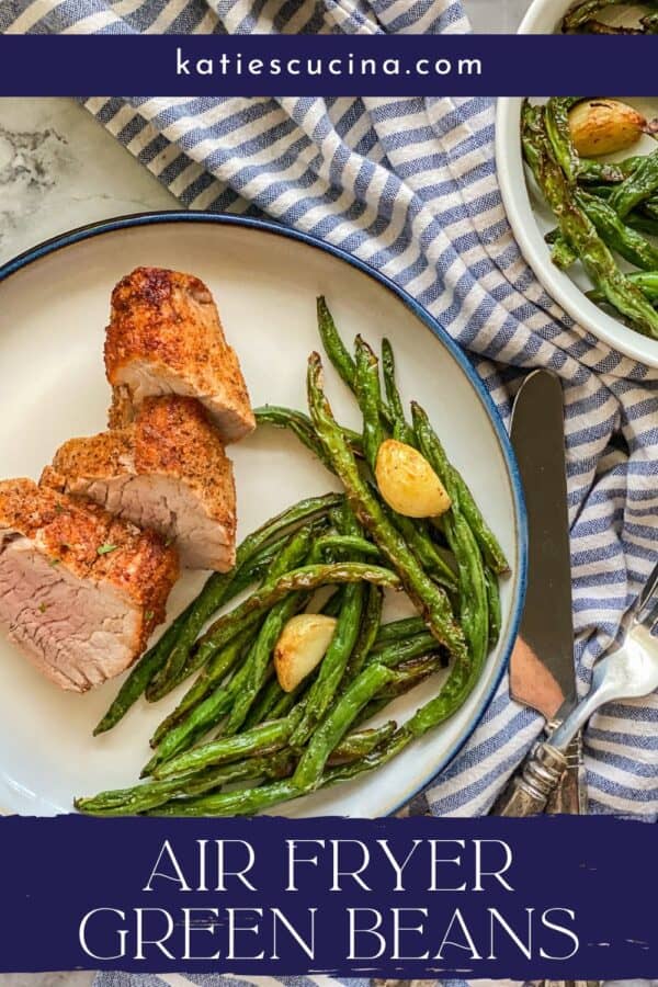 a white plate on a white counter with a blue and white napkin with pork slices next to green beans with garlic