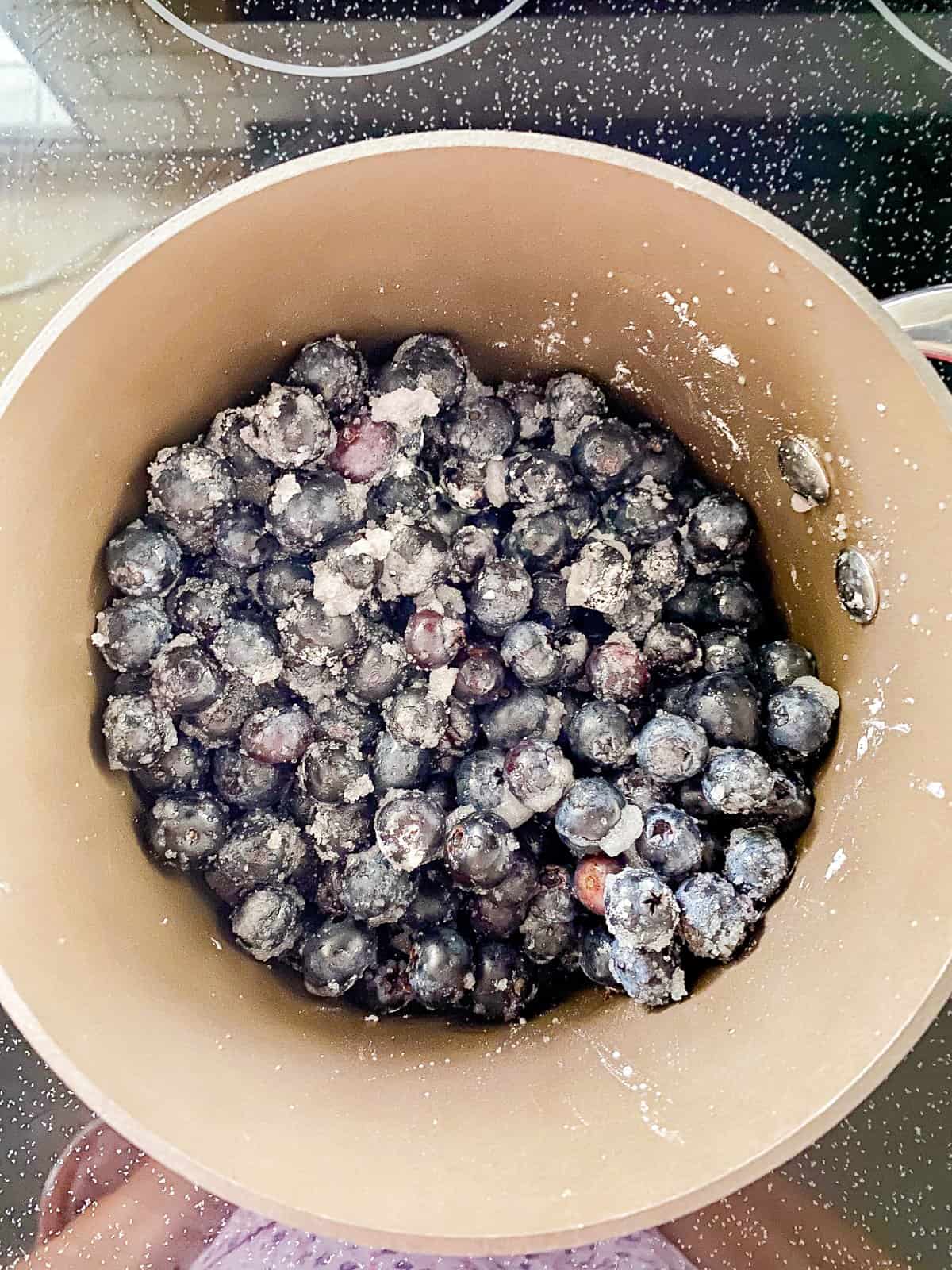 a bowl filled with blueberries covered in white sugar.