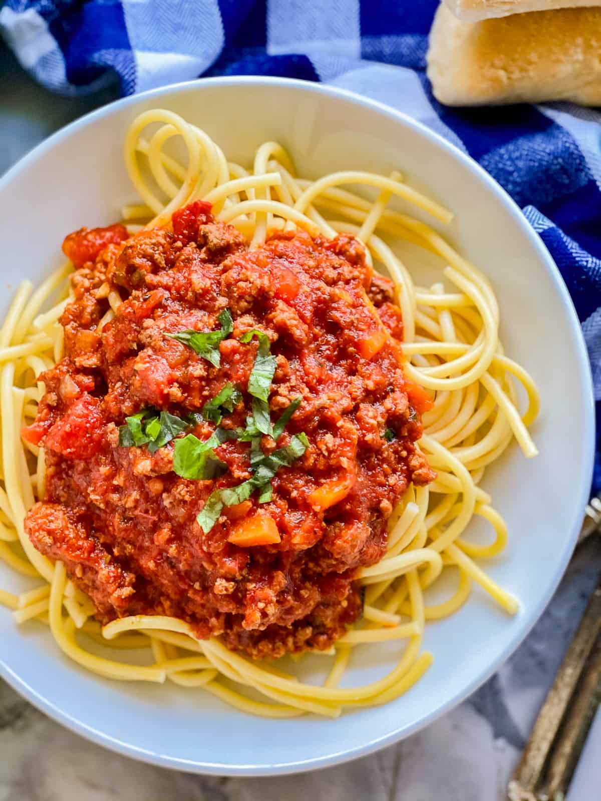 top view of yellow spaghetti with red sauce on top.