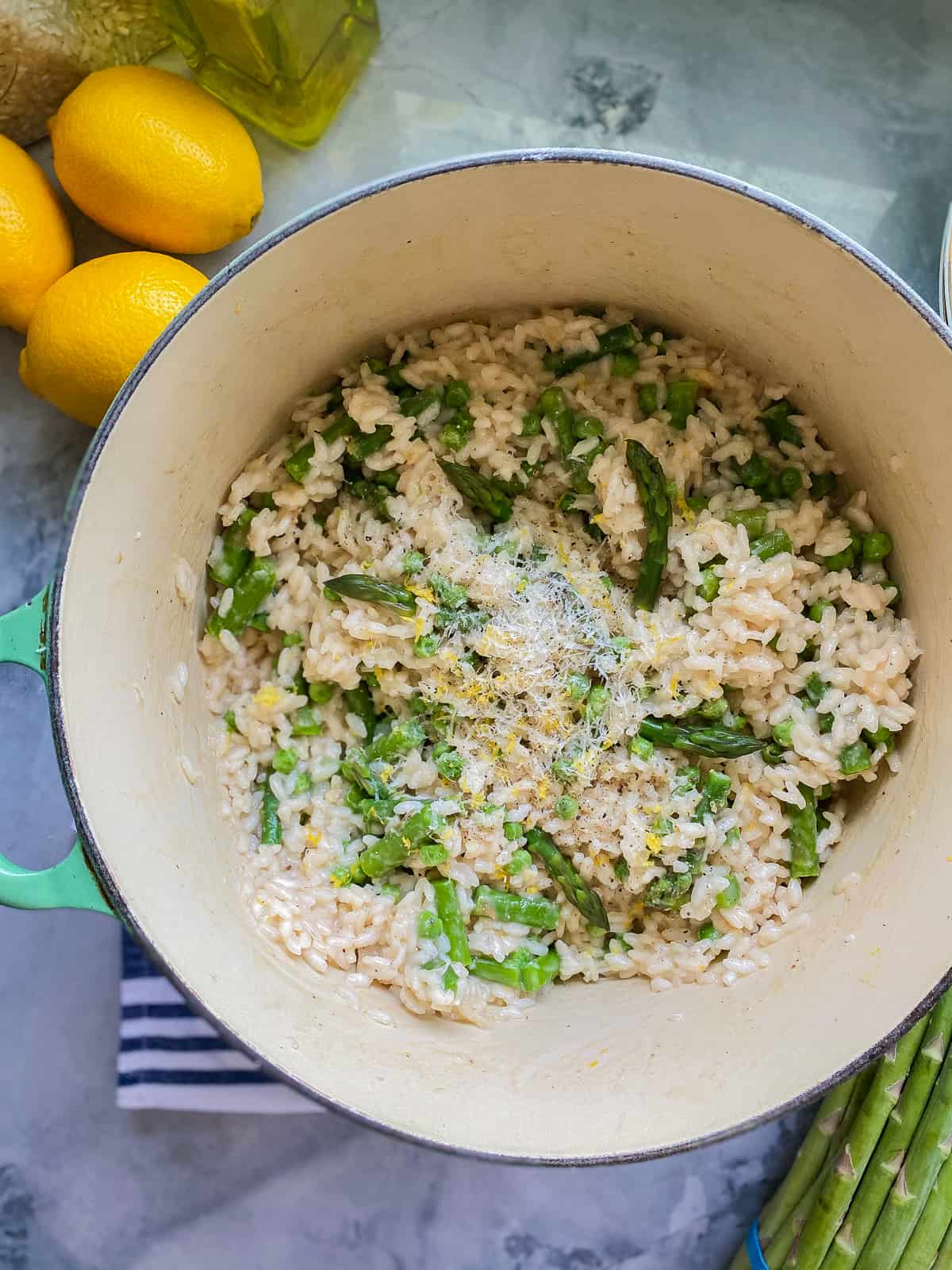 Green pot filled with rice, peas, asparagus, and cheese.