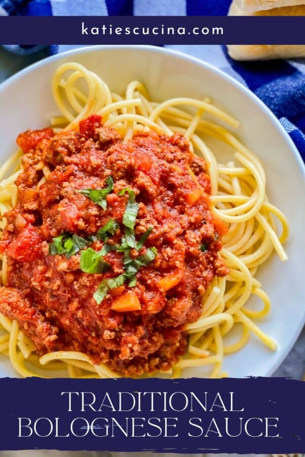 White plate with yellow spaghetti with red sauce on top and blue banner with white text on the bottom.