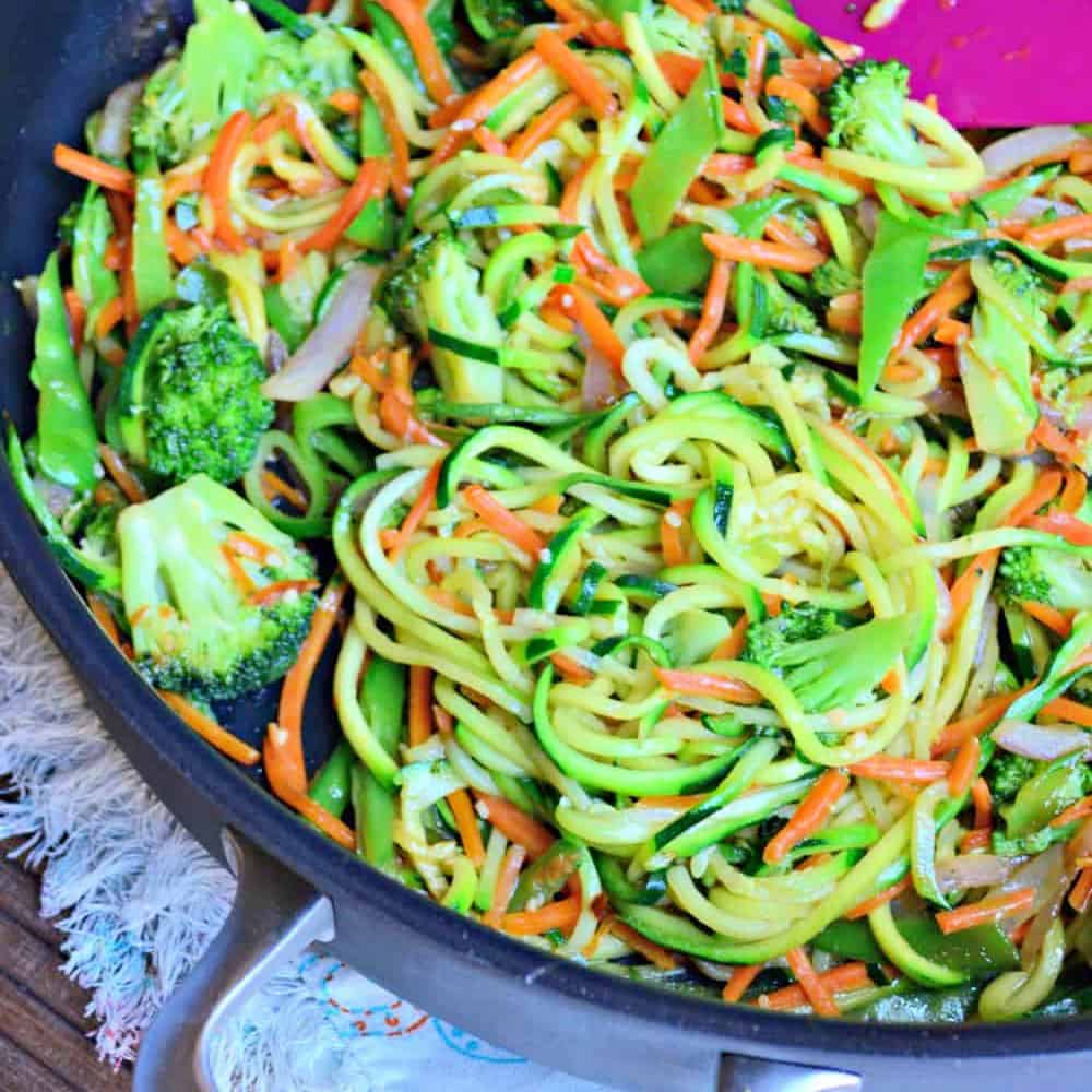 skillet with zucchini noodles, carrots, and broccoli.