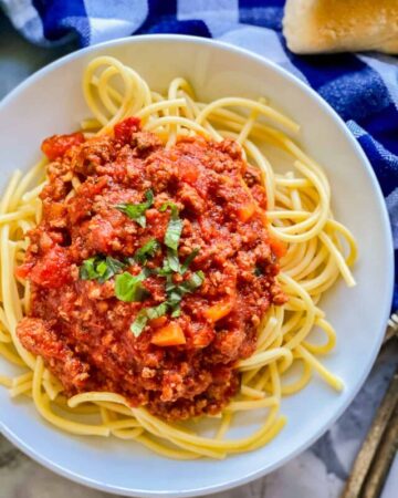 top view of yellow spaghetti with red sauce on top.