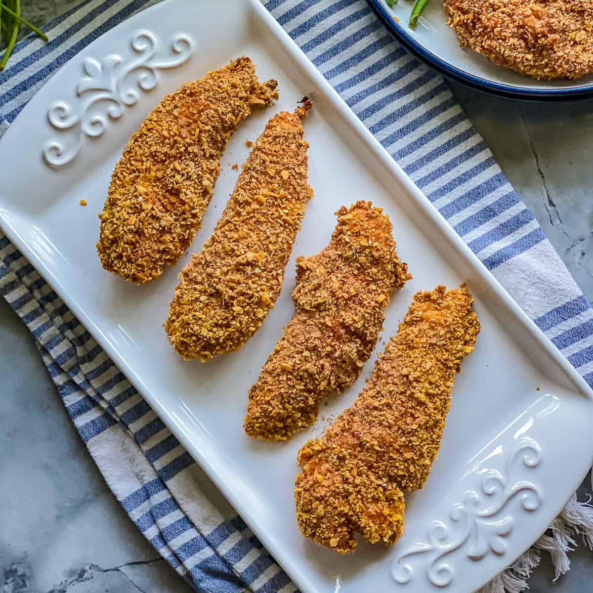 White plate with four chicken strips