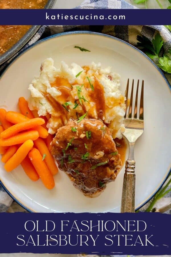 white plate with blue trim with white mash potatoes, orange carrots, brown steak with gravy with silver fork with blue banner with white lettering.