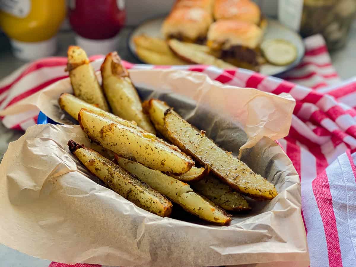 Blue basket filled with parchment and potato wedges.