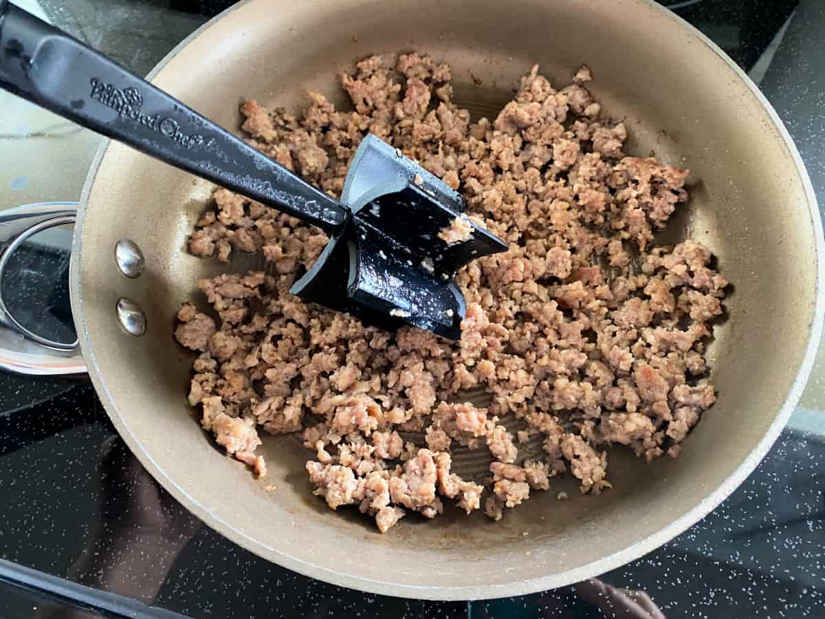 Metal pan with ground sausage with a meat grinder.