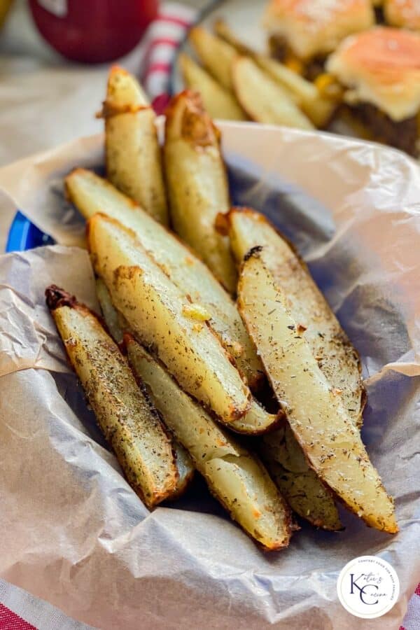 Blue basket filled with potato wedges with logo on right corner.