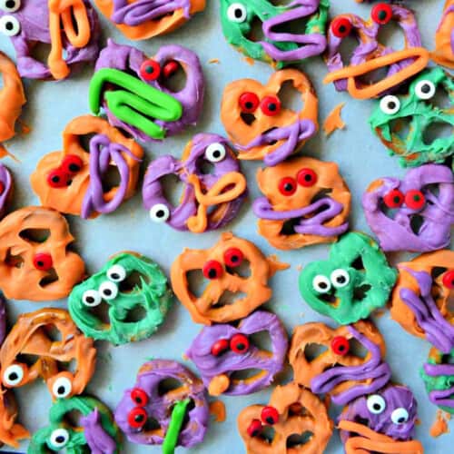 Pretzels dipped in colored white chocolate with eyeballs on the pretzels.