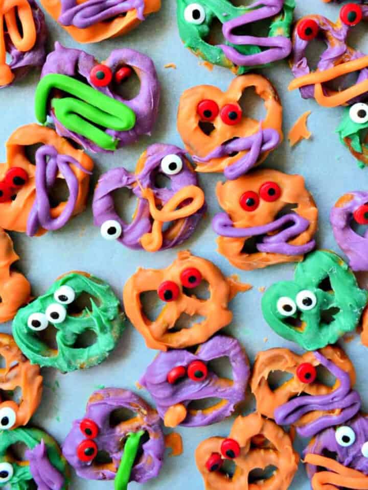 Pretzels dipped in colored white chocolate with eyeballs on the pretzels.