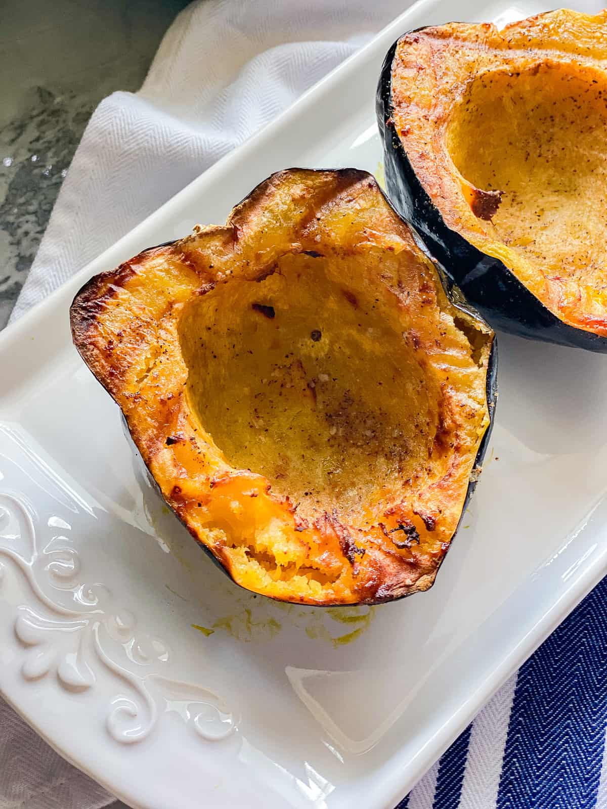 White platter with a close up of two cooked acorn squash.