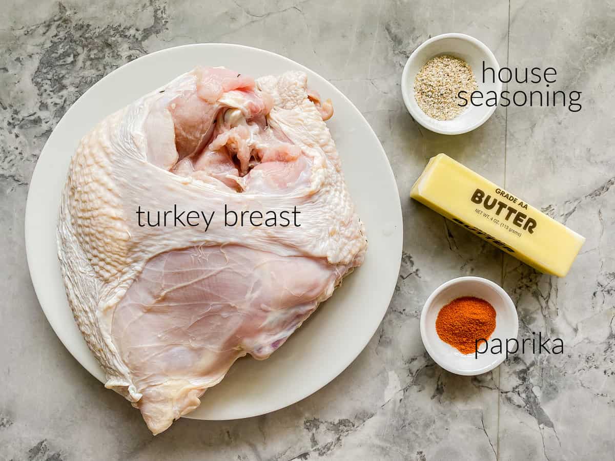 Ingredients on countertop; turkey breast, house seasoning, butter, and aprika.