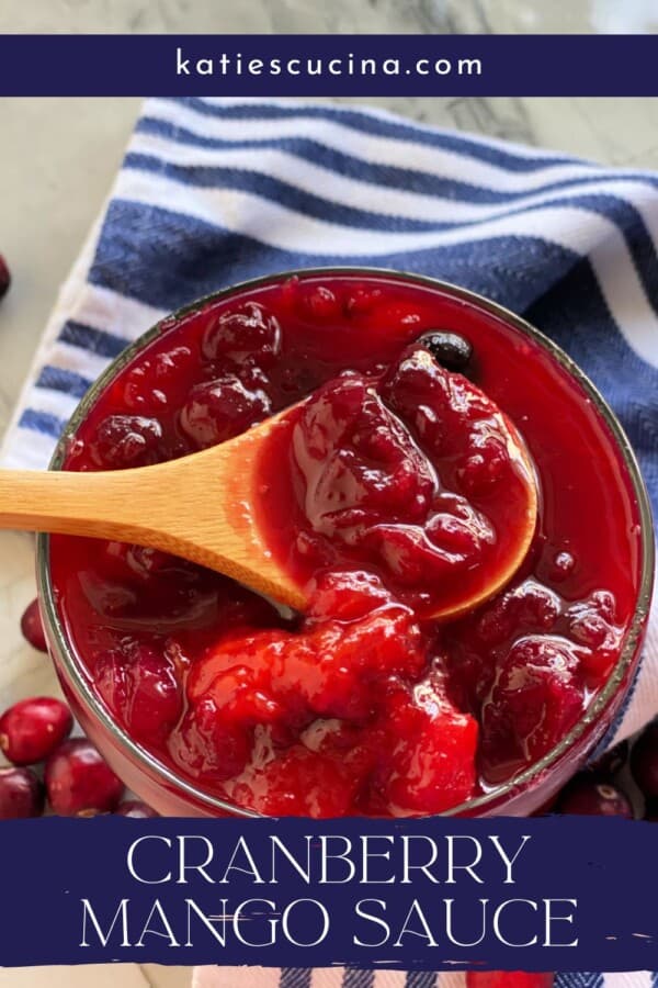 Wooden spoon in a glass bowl filled with cranberry sauce with recipe title text on image for Pinterest.