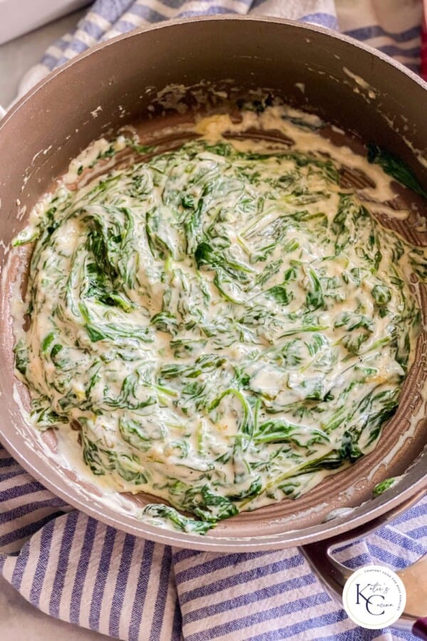 Brown pot filled with creamed spinach with logo on right corner.