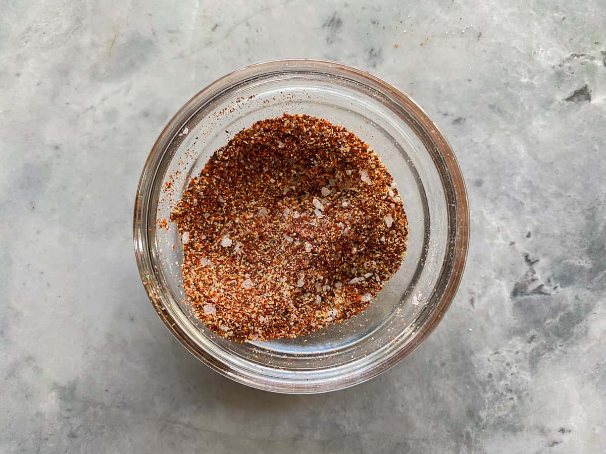 Glass bowl on a marble countertop filled with spices.