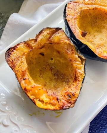 White platter with a close up of two cooked acorn squash.