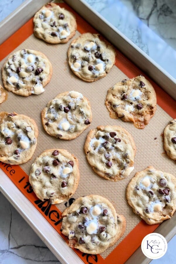 Baking sheet filled with 12 baked cookies with logo on right bottom corner.