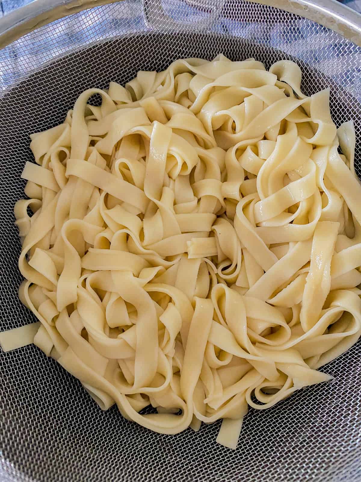 Strainer filled with cooked linguine