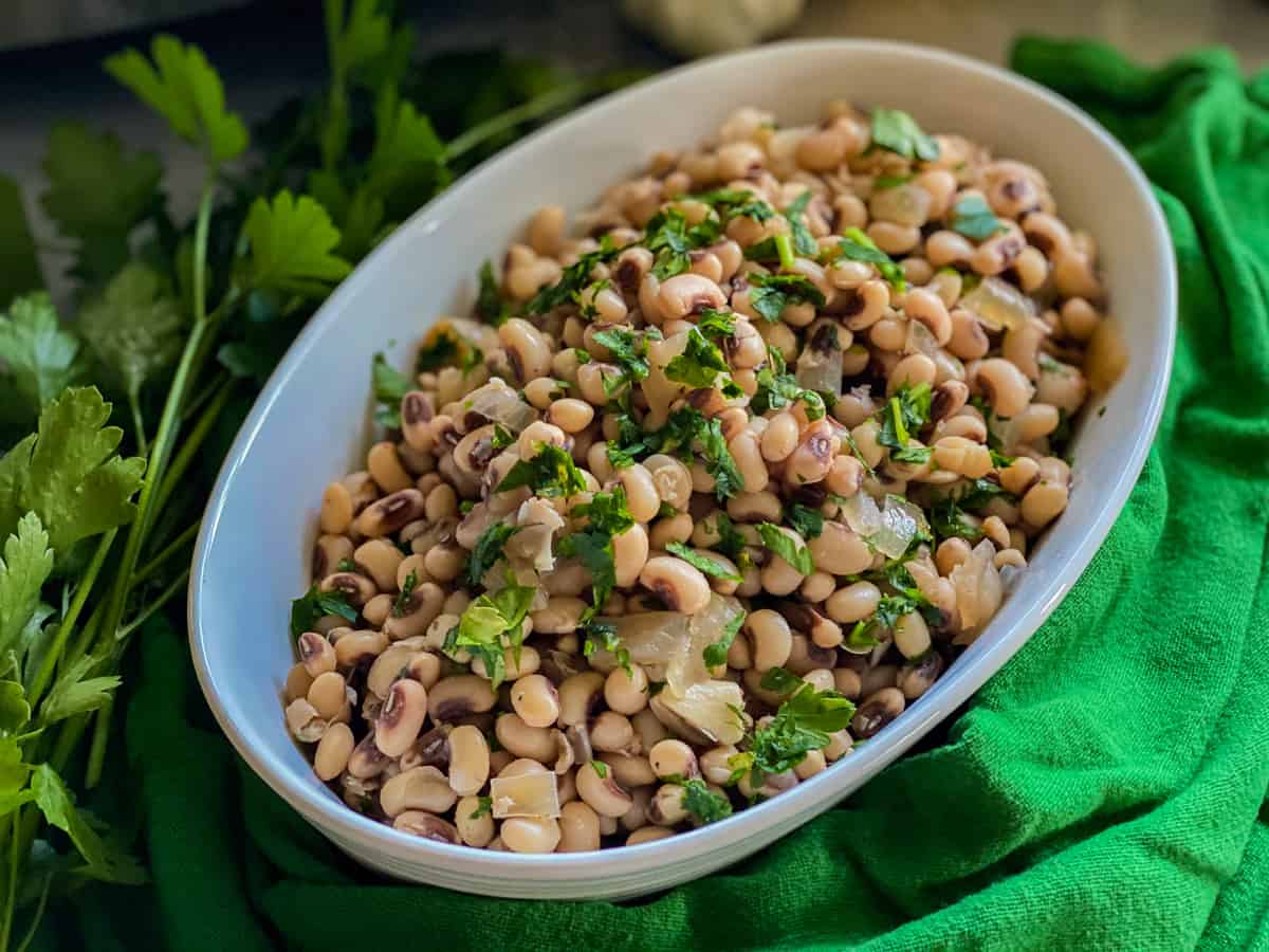 cooked black eyed peas with parsley in an oval dish.