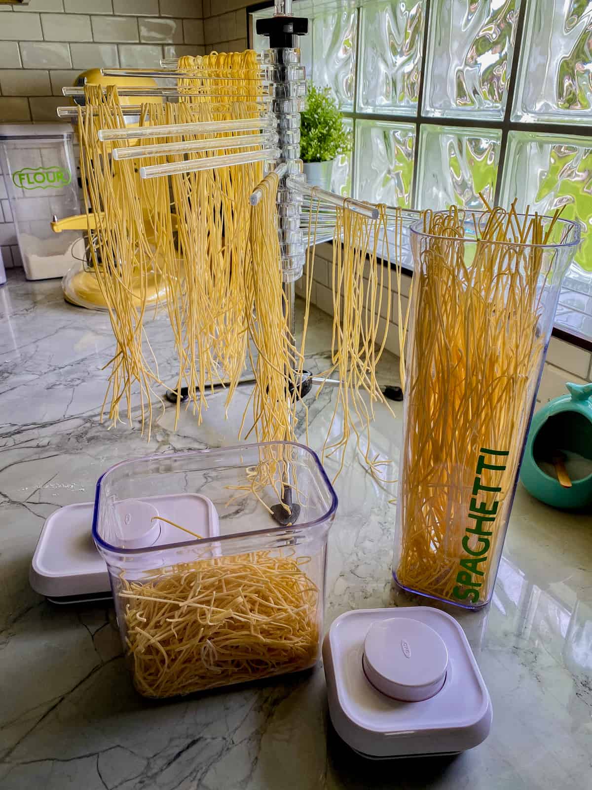 Pasta drying rack with dried pasta in a container.