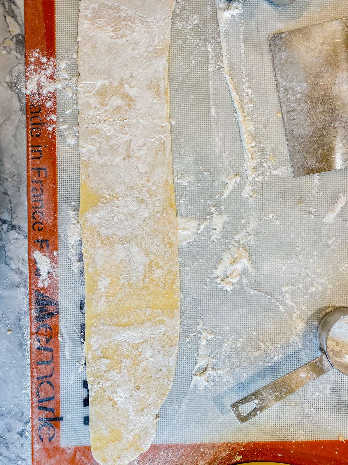 Sheet of fresh pasta dough on a floured Silpat mat.