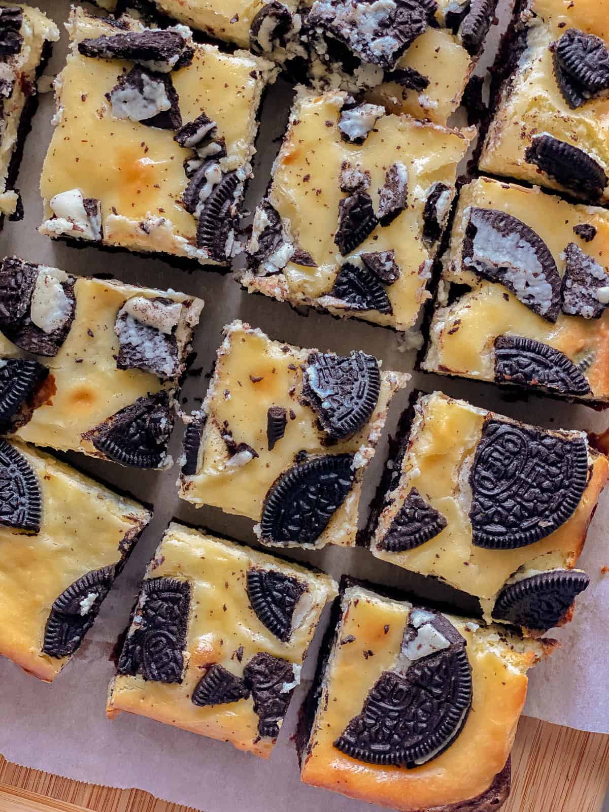 Sliced cheesecake bars with OREO's on top.