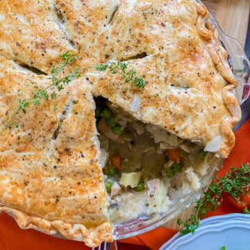 Close up of a turkey pot pie with a slice taken out of it.