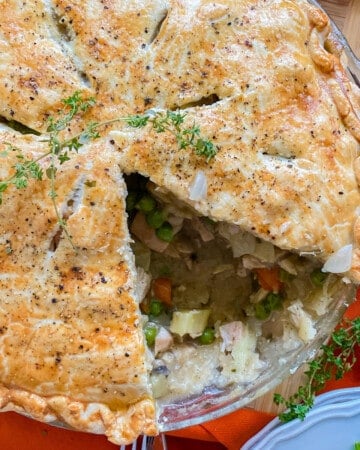 Close up of a turkey pot pie with a slice taken out of it.
