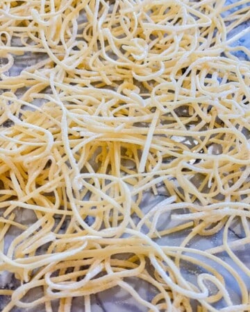 Fresh spaghetti dough on a countertop.